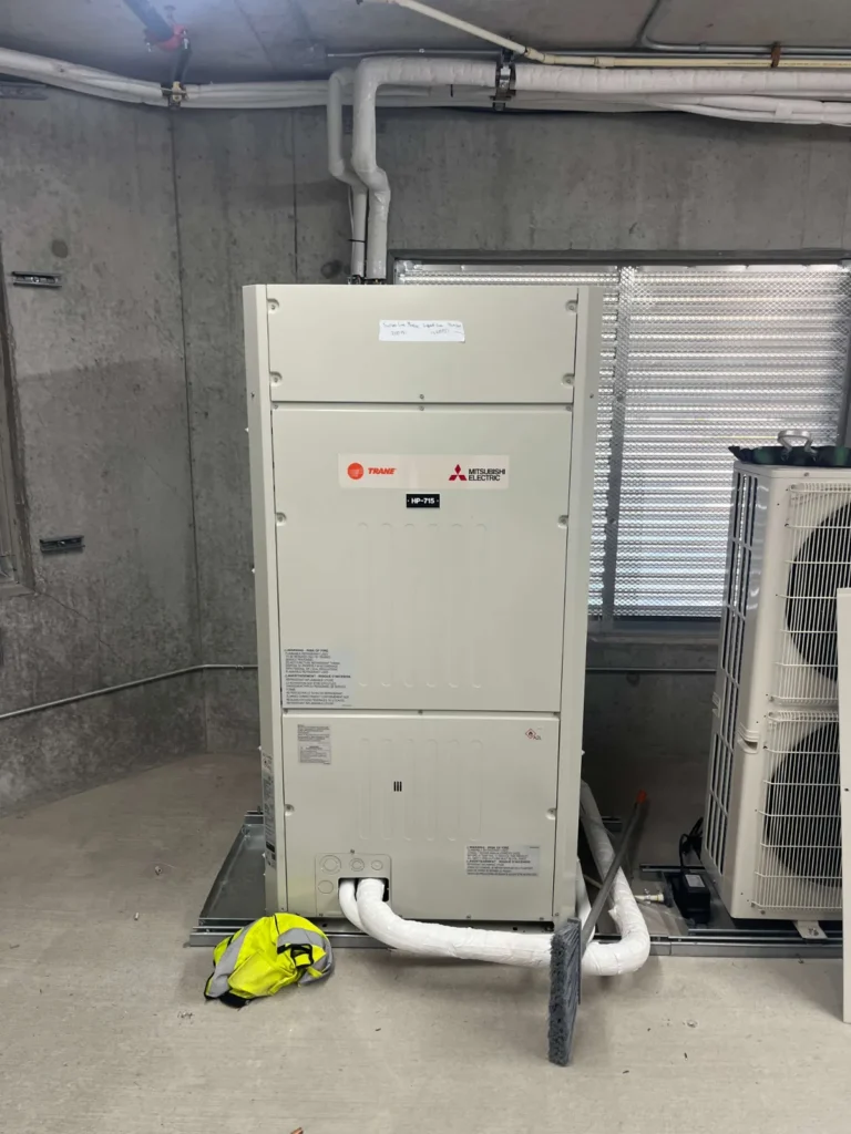 Vertical air handler and heat pump outdoor unit installed in a mechanical room