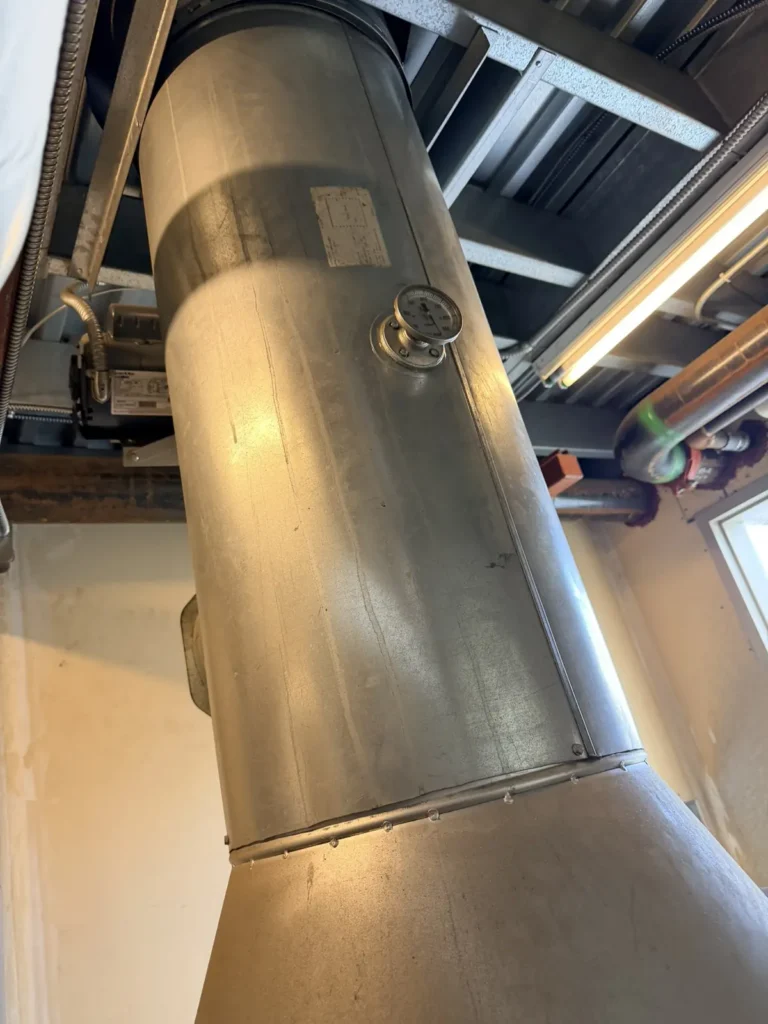 Large stainless boiler flue in a commercial mechanical room