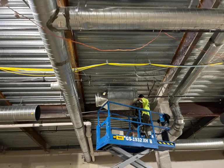 Our install crew on a lift hanging ductwork