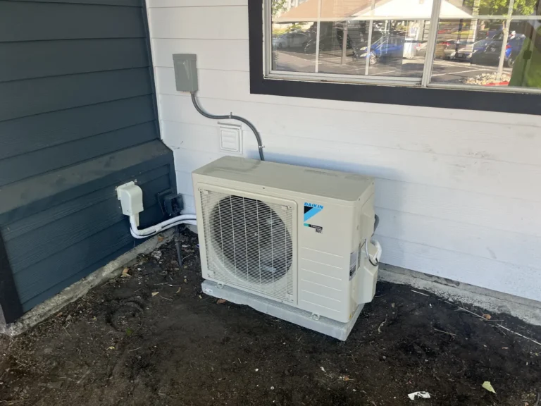 Ductless heat pump condenser installed at a building corner