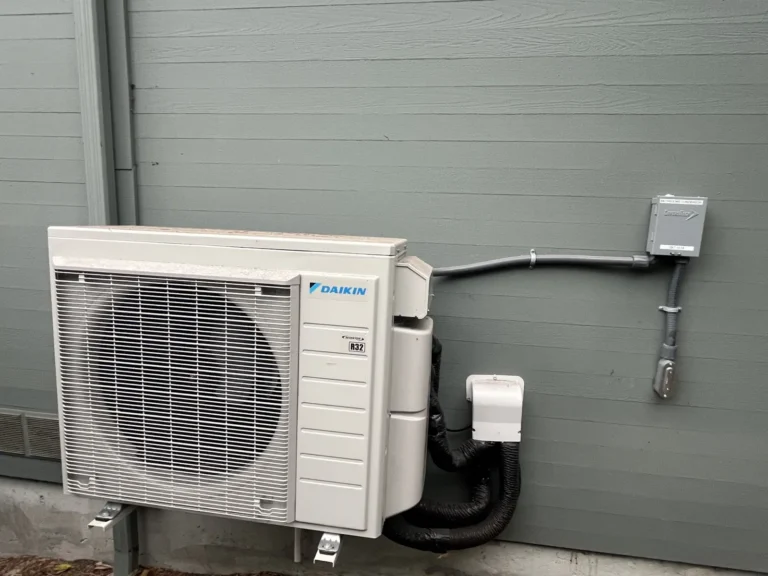 Daikin heat pump condenser mounted on a commercial building wall
