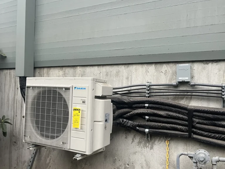 Wall-mounted Daikin heat pump condenser with neatly bundled line sets
