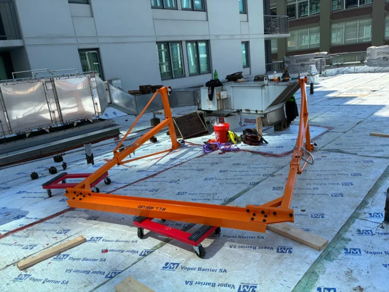 Rigging frame and dolly staged to move rooftop HVAC equipment during a roof replacement