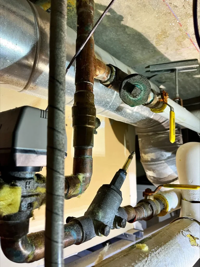 Insulated hydronic piping and valve assembly in a ceiling space