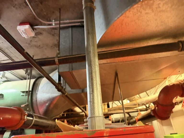 Commercial mechanical room with large ductwork and piping