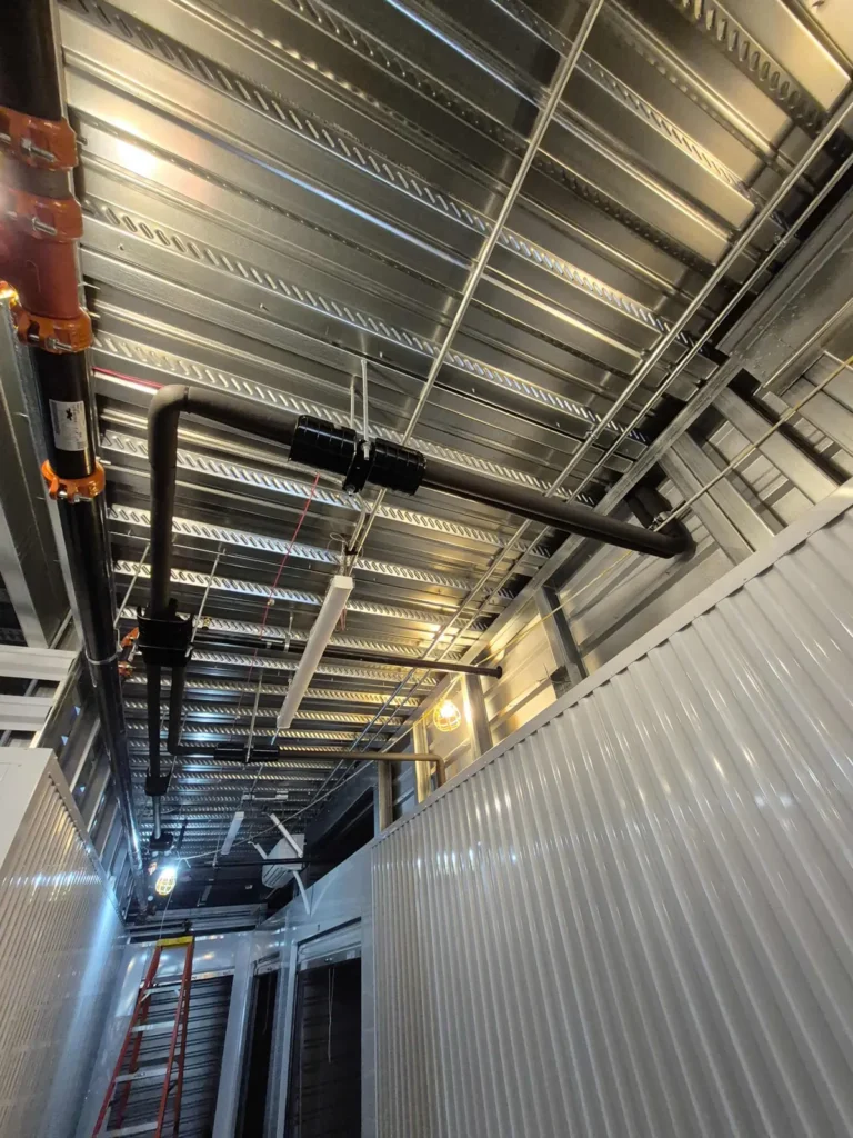 Insulated refrigerant piping run along a metal ceiling deck
