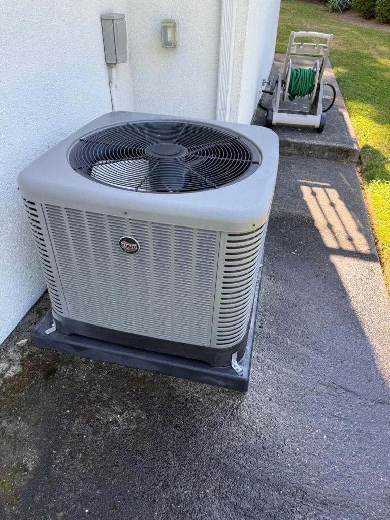 Residential heat pump condenser outside a home