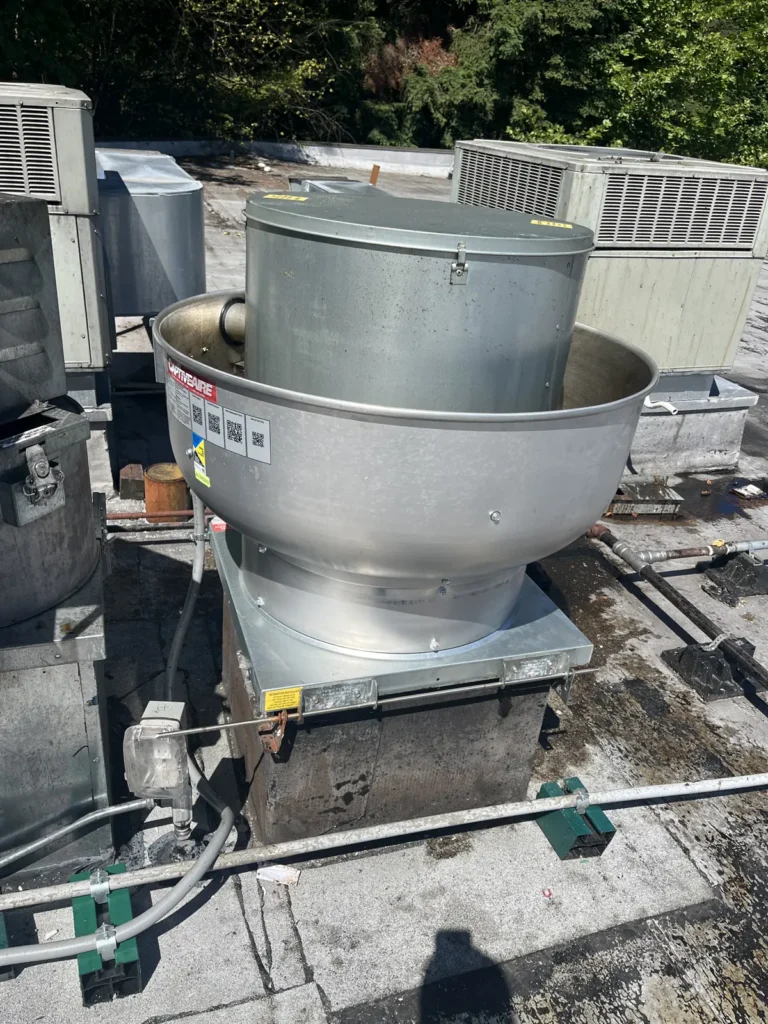 New rooftop exhaust fan among rooftop units on a commercial roof in Woodinville