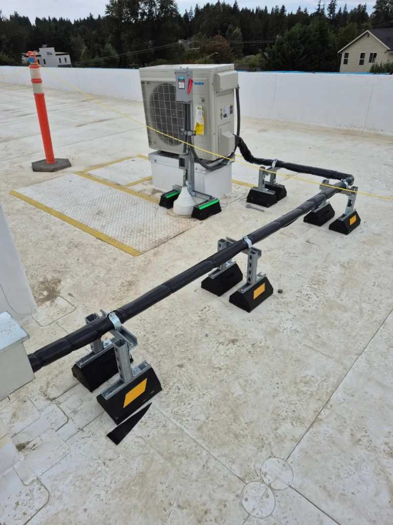 Rooftop heat pump condenser with line sets run on roof pipe supports